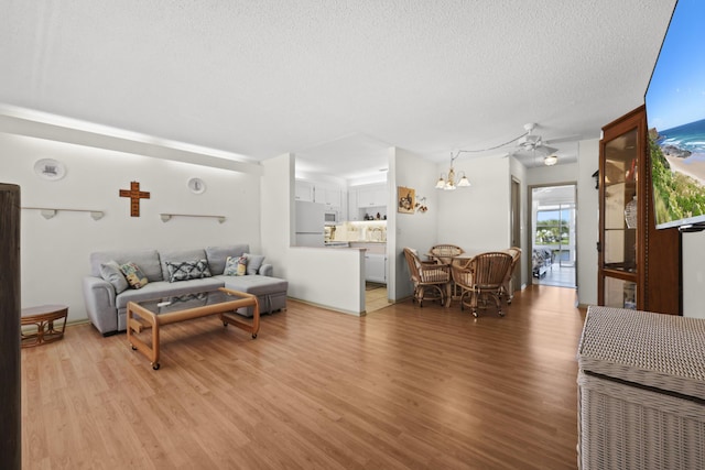 2800 Indian River Blvd Unit 7T, Vero Beach, FL 32960 - living room with light wood-type flooring, a chandelier, a textured ceiling, and a ceiling fan