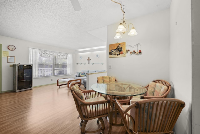 2800 Indian River Blvd Unit 7T, Vero Beach, FL 32960 - dining room featuring wood finished floors, a chandelier, a textured ceiling, and a ceiling fan