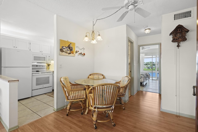 2800 Indian River Blvd Unit 7T, Vero Beach, FL 32960 - dining area with light wood-style floors, a ceiling fan, a chandelier, and a textured ceiling