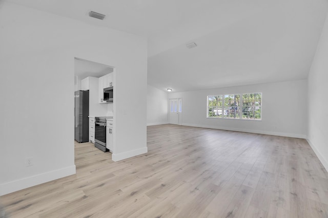 2432 SE Floresta Dr, Port Saint Lucie, FL 34984 - unfurnished living room featuring light wood-style floors and lofted ceiling