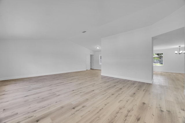 2432 SE Floresta Dr, Port Saint Lucie, FL 34984 - unfurnished living room featuring vaulted ceiling, light wood-style floors, and a chandelier