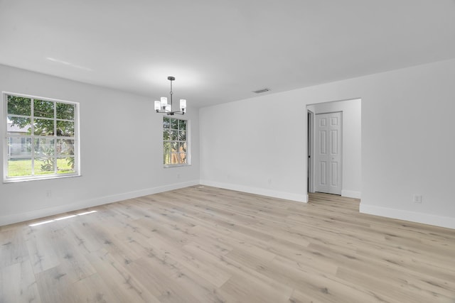 2432 SE Floresta Dr, Port Saint Lucie, FL 34984 - empty room with a chandelier, healthy amount of natural light, and light wood finished floors