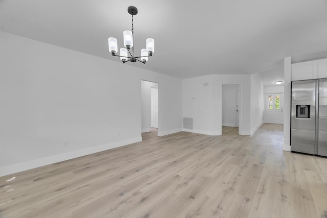 2432 SE Floresta Dr, Port Saint Lucie, FL 34984 - unfurnished living room with a chandelier and light wood finished floors