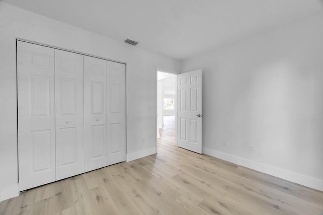 2432 SE Floresta Dr, Port Saint Lucie, FL 34984 - unfurnished bedroom with light wood-style floors and a closet