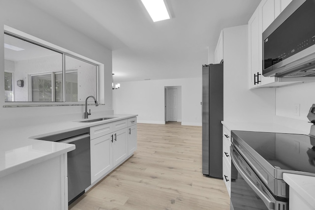 2432 SE Floresta Dr, Port Saint Lucie, FL 34984 - kitchen featuring appliances with stainless steel finishes, white cabinets, light wood-style flooring, and light countertops
