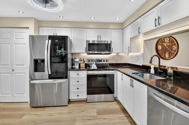 7270 Ashford Pl Unit 104, Delray Beach, FL 33446 - kitchen featuring appliances with stainless steel finishes, white cabinets, tasteful backsplash, light wood finished floors, and recessed lighting