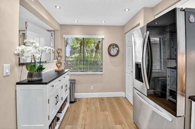 7270 Ashford Pl Unit 104, Delray Beach, FL 33446 - kitchen with stainless steel fridge with ice dispenser, dark countertops, white cabinetry, light wood-type flooring, and recessed lighting