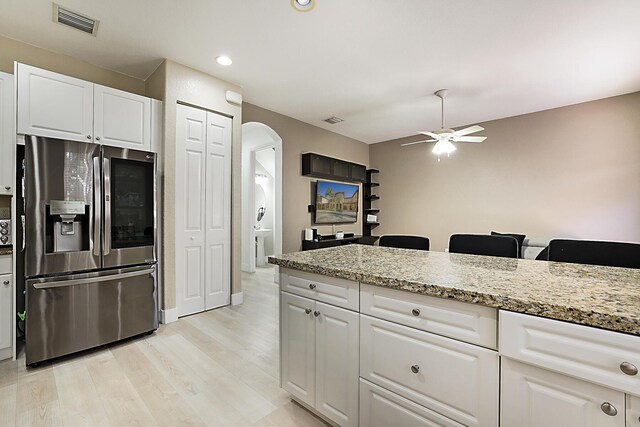 6964 Julia Gardens Dr, Coconut Creek, FL 33073 - kitchen featuring stainless steel refrigerator with ice dispenser, arched walkways, a ceiling fan, light wood-style flooring, and white cabinets