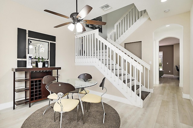 6964 Julia Gardens Dr, Coconut Creek, FL 33073 - dining area with arched walkways, stairs, wood finished floors, a ceiling fan, and recessed lighting
