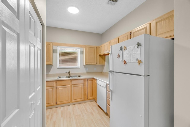 420 Hawthorne Ln, Vero Beach, FL 32962 - kitchen featuring white appliances, light brown cabinetry, light countertops, and light wood-style flooring