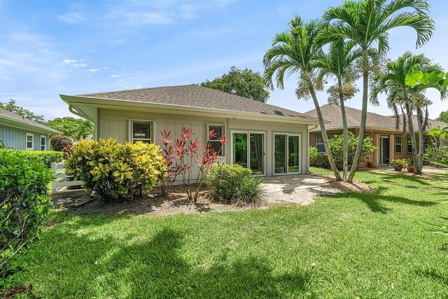 420 Hawthorne Ln, Vero Beach, FL 32962 - rear view of property featuring a lawn, a patio area, and a shingled roof