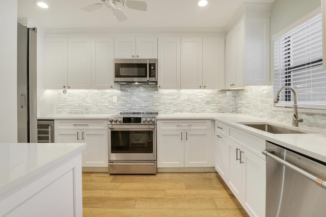 300 Intracoastal Pl Unit 204, Jupiter, FL 33469 - kitchen with appliances with stainless steel finishes, beverage cooler, white cabinetry, light countertops, and recessed lighting