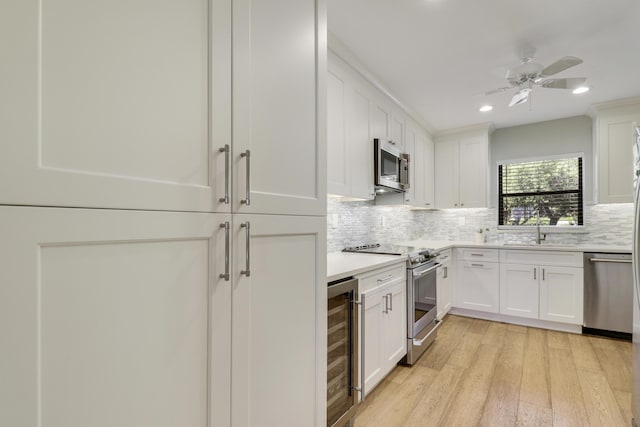 300 Intracoastal Pl Unit 204, Jupiter, FL 33469 - kitchen with beverage cooler, stainless steel appliances, light wood-style flooring, tasteful backsplash, and white cabinetry