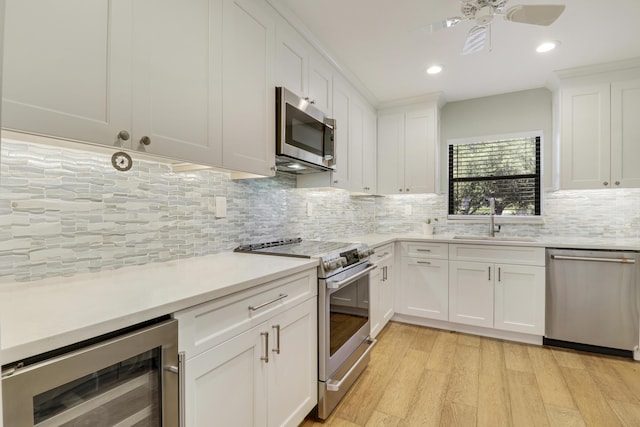 300 Intracoastal Pl Unit 204, Jupiter, FL 33469 - kitchen with stainless steel appliances, beverage cooler, light wood-style floors, light countertops, and tasteful backsplash