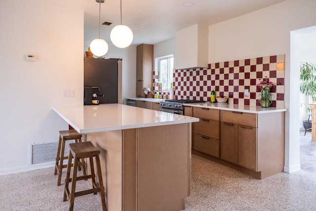 2931 SE Morningside Blvd, Port Saint Lucie, FL 34952 - kitchen featuring a peninsula, stainless steel appliances, a kitchen breakfast bar, decorative backsplash, and brown cabinetry