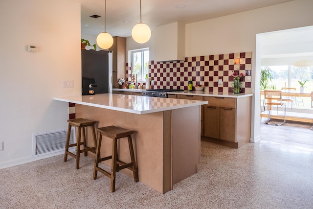 2931 SE Morningside Blvd, Port Saint Lucie, FL 34952 - kitchen with freestanding refrigerator, a kitchen breakfast bar, range, hanging light fixtures, and light countertops
