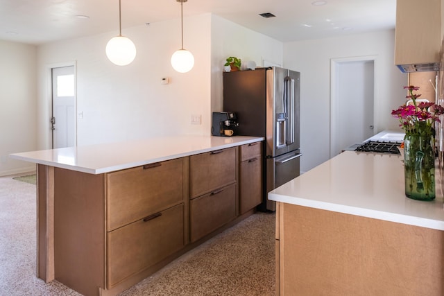 2931 SE Morningside Blvd, Port Saint Lucie, FL 34952 - kitchen with a peninsula, light countertops, stainless steel refrigerator with ice dispenser, brown cabinetry, and decorative light fixtures
