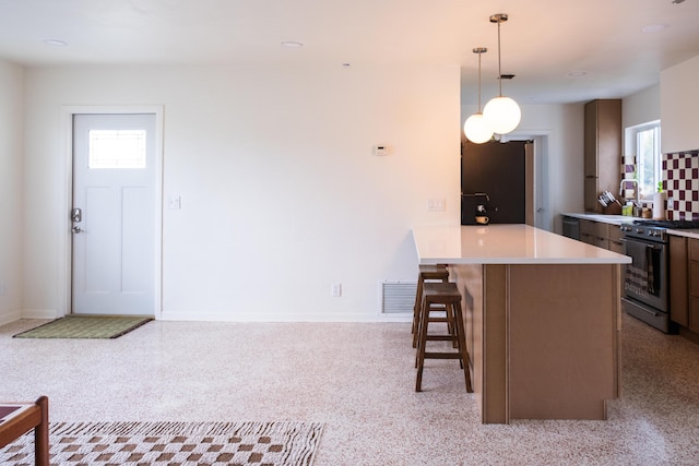 2931 SE Morningside Blvd, Port Saint Lucie, FL 34952 - kitchen with high end stainless steel range oven, a kitchen breakfast bar, light countertops, a peninsula, and decorative light fixtures