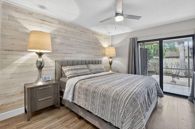 1005 NW 53rd St, Deerfield Beach, FL 33064 - bedroom with wooden walls, an accent wall, a textured ceiling, access to outside, and wood finished floors