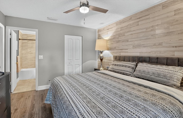 1005 NW 53rd St, Deerfield Beach, FL 33064 - bedroom with wood walls, an accent wall, a textured ceiling, light wood-style flooring, and ceiling fan