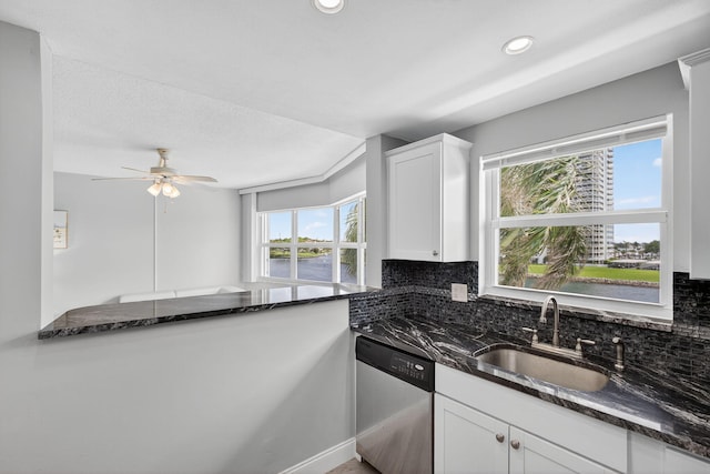 28 Yacht Club Dr Unit 409, North Palm Beach, FL 33408 - kitchen featuring stainless steel dishwasher, backsplash, dark stone counters, white cabinetry, and a ceiling fan
