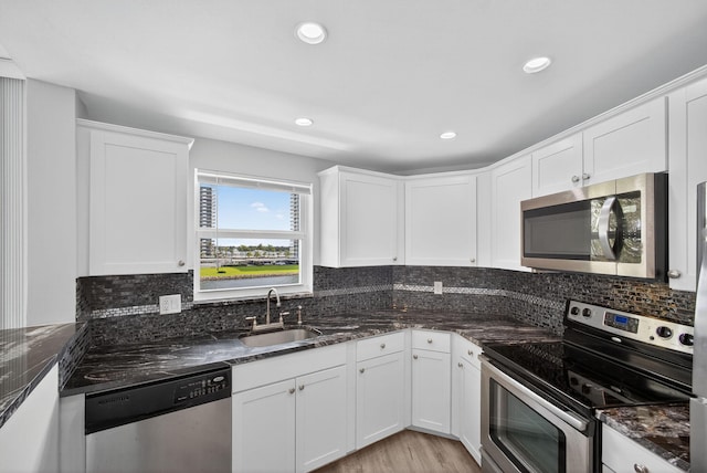 28 Yacht Club Dr Unit 409, North Palm Beach, FL 33408 - kitchen featuring appliances with stainless steel finishes, white cabinets, dark stone countertops, and recessed lighting