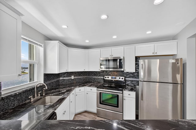 28 Yacht Club Dr Unit 409, North Palm Beach, FL 33408 - kitchen with stainless steel appliances, dark stone counters, backsplash, white cabinets, and recessed lighting
