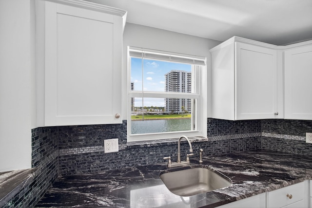 28 Yacht Club Dr Unit 409, North Palm Beach, FL 33408 - kitchen featuring backsplash, white cabinetry, and dark stone counters