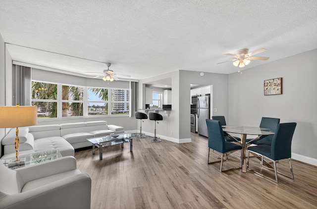 28 Yacht Club Dr Unit 409, North Palm Beach, FL 33408 - living area featuring a ceiling fan, a textured ceiling, and light wood-style floors