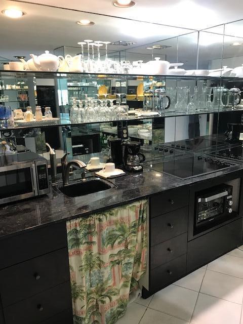 2600 N Flagler Dr Unit Ph13, West Palm Beach, FL 33407 - indoor wet bar with black electric cooktop, stainless steel microwave, and light tile patterned flooring