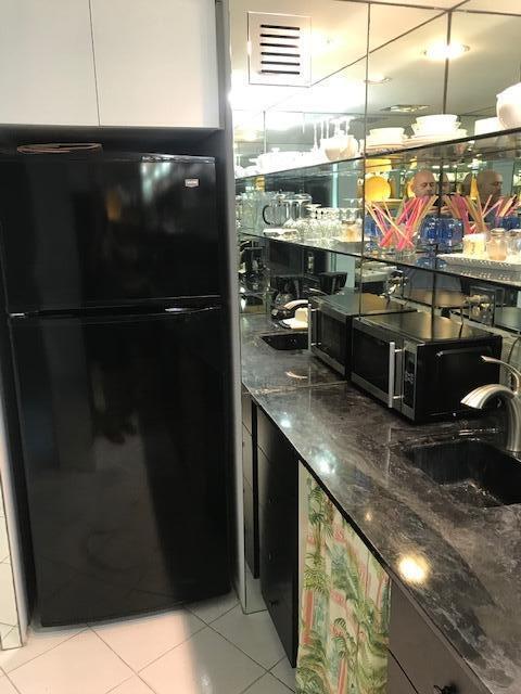 2600 N Flagler Dr Unit Ph13, West Palm Beach, FL 33407 - bar area with freestanding refrigerator, stainless steel microwave, and light tile patterned flooring