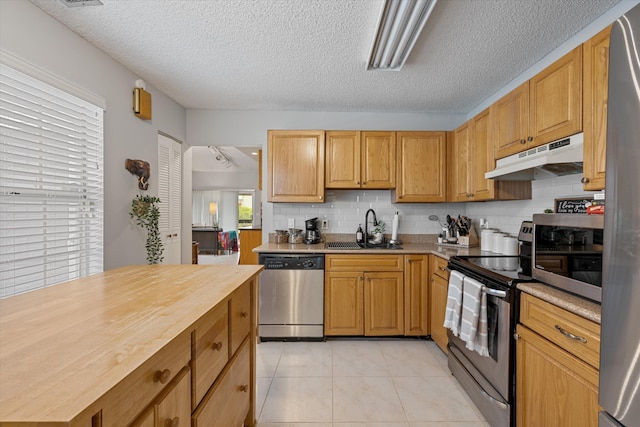 3809 Island Club Cir E, Lake Worth, FL 33462 - kitchen with stainless steel appliances, under cabinet range hood, decorative backsplash, a textured ceiling, and butcher block countertops