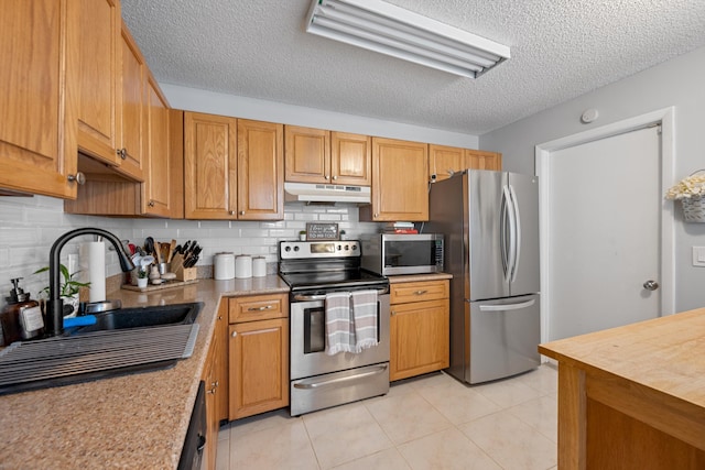 3809 Island Club Cir E, Lake Worth, FL 33462 - kitchen with appliances with stainless steel finishes, under cabinet range hood, a textured ceiling, backsplash, and light countertops