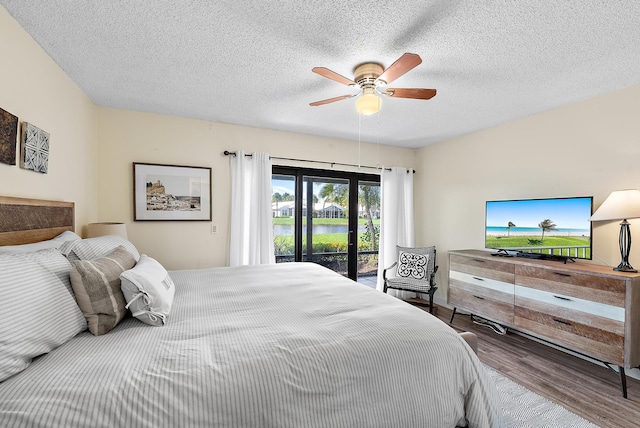 3733 Cape Pointe Cir, Jupiter, FL 33477 - bedroom with access to outside, wood finished floors, a ceiling fan, and a textured ceiling