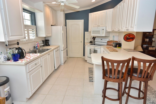 715 SW Balmoral Trce, Stuart, FL 34997 - kitchen with white appliances, light countertops, tasteful backsplash, a peninsula, and a kitchen breakfast bar