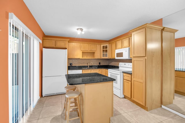 5693 SE Windsong Ln Unit 545, Stuart, FL 34997 - kitchen with white appliances, light brown cabinets, backsplash, a center island, and a breakfast bar area