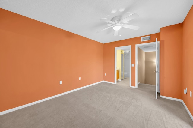 5693 SE Windsong Ln Unit 545, Stuart, FL 34997 - unfurnished bedroom featuring a walk in closet, light carpet, ceiling fan, and a closet