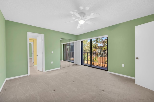 5693 SE Windsong Ln Unit 545, Stuart, FL 34997 - unfurnished bedroom featuring access to exterior, carpet floors, a textured ceiling, and ceiling fan
