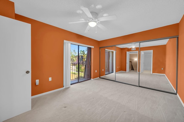 5693 SE Windsong Ln Unit 545, Stuart, FL 34997 - unfurnished bedroom featuring access to exterior, carpet floors, a textured ceiling, and ceiling fan