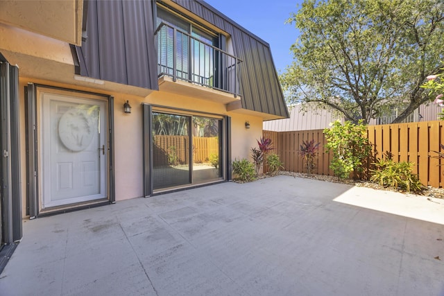 5693 SE Windsong Ln Unit 545, Stuart, FL 34997 - view of exterior entry featuring a patio, stucco siding, mansard roof, and a balcony