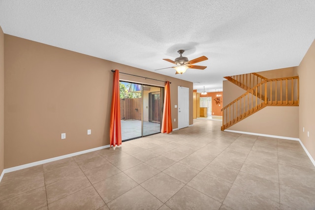 5693 SE Windsong Ln Unit 545, Stuart, FL 34997 - spare room featuring stairs, ceiling fan, a textured ceiling, and light tile patterned floors