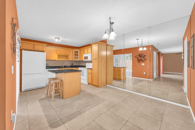 5693 SE Windsong Ln Unit 545, Stuart, FL 34997 - kitchen with white appliances, a center island, light tile patterned flooring, glass insert cabinets, and a breakfast bar area