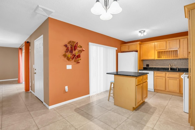 5693 SE Windsong Ln Unit 545, Stuart, FL 34997 - kitchen with refrigerator, white dishwasher, a kitchen island, decorative backsplash, and dark countertops