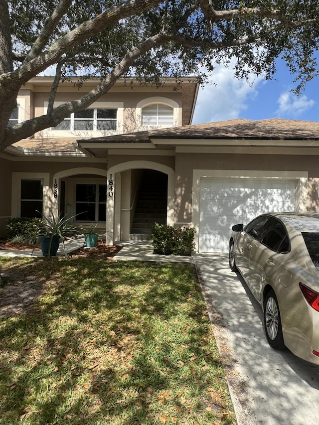 1840 S Dovetail Dr, Fort Pierce, FL 34982 - view of front of home with concrete driveway, a garage, stucco siding, a front lawn, and a balcony