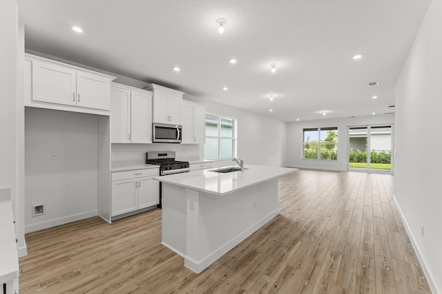 9555 SW Indra Way, Port Saint Lucie, FL 34987 - kitchen with appliances with stainless steel finishes, white cabinets, light wood-style floors, and recessed lighting