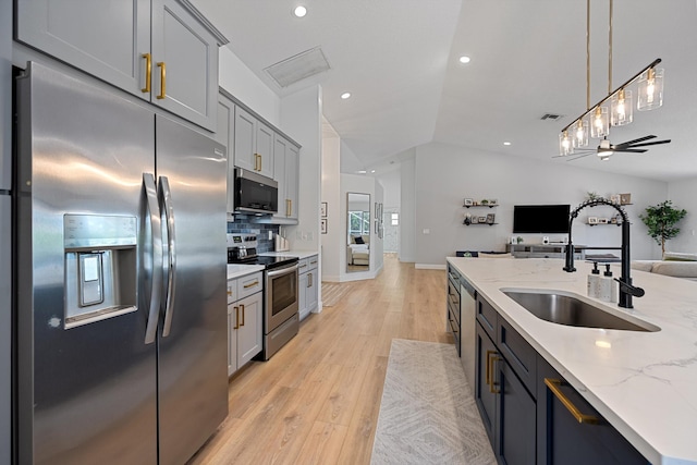 6572 Brookhurst Cir, Lake Worth, FL 33463 - kitchen with stainless steel appliances, open floor plan, light wood finished floors, backsplash, and decorative light fixtures
