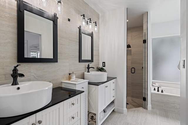 6572 Brookhurst Cir, Lake Worth, FL 33463 - full bath featuring a stall shower, two vanities, a garden tub, tile walls, and decorative backsplash