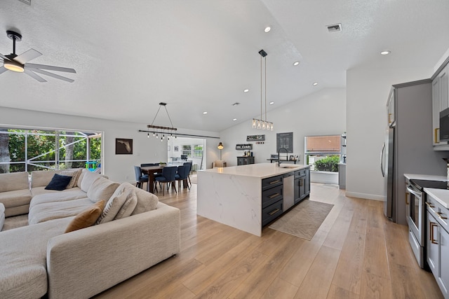 6572 Brookhurst Cir, Lake Worth, FL 33463 - kitchen with open floor plan, stainless steel appliances, recessed lighting, a center island with sink, and decorative light fixtures
