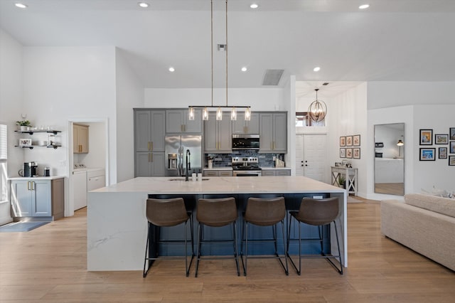 6572 Brookhurst Cir, Lake Worth, FL 33463 - kitchen featuring stainless steel appliances, separate washer and dryer, gray cabinetry, light wood-style flooring, and recessed lighting