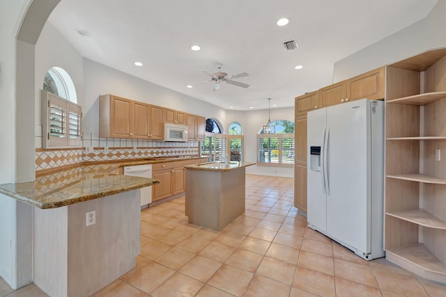 163 Pepper Ln, Jensen Beach, FL 34957 - kitchen with white appliances, a ceiling fan, light stone countertops, decorative backsplash, and an island with sink